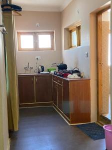 a kitchen with wooden cabinets and a sink at Hotel Latso Ladakh in Leh