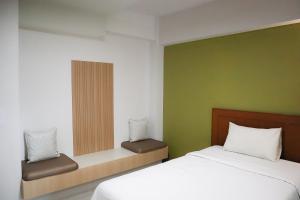 a bedroom with a white bed and a green wall at 100House Hotel Korat in Ban Hua La Loeng +13 photos