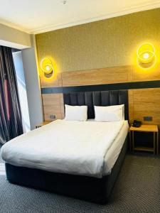 a bed in a hotel room with a white bed sidx sidx sidx at Golden Palace Hotel in Almaty +58 photos