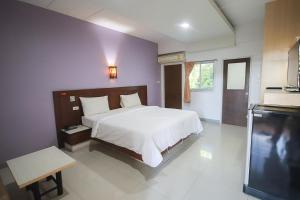 a bedroom with a bed and a flat screen tv at 100House Hotel Korat in Ban Hua La Loeng