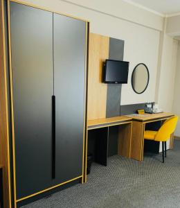 a sliding glass door in a room with a desk at Golden Palace Hotel in Almaty