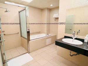 a bathroom with a shower and a tub and a sink at Huis Ten Bosch in Ren'ai +28 photos