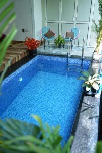 a swimming pool with two chairs and a table at Sundown Resort in Noida