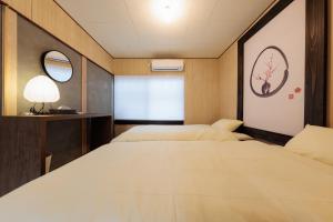 two beds in a room with two mirrors at 穂庵-Hoan- in Tanabe