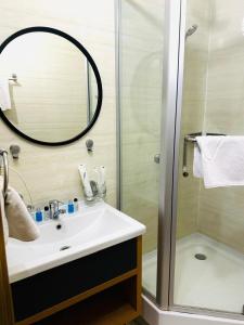 a bathroom with a sink and a shower with a mirror at Golden Palace Hotel in Almaty