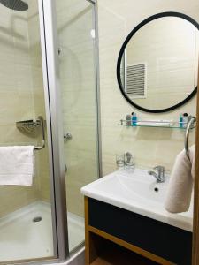 a bathroom with a sink and a shower with a mirror at Golden Palace Hotel in Almaty