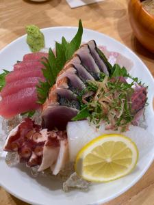 a plate of food with fish and vegetables on a table at ゲストハウス有無 in Mihama