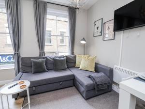 a living room with a couch and a tv at Brinkleys Nook in Whitby