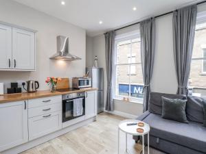 a kitchen and living room with a couch and a table at Brinkleys Nook in Whitby