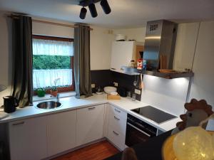 a kitchen with white cabinets and a sink and a window at Ferienwohnung am Ulrichsgrünbach in Waldmünchen