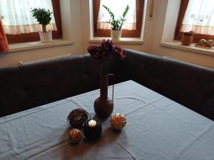 a table with a vase with flowers and balls on it at Ferienwohnung am Ulrichsgrünbach in Waldmünchen