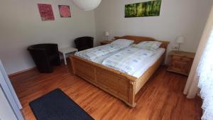 a bedroom with a wooden bed with a wooden floor at Ferienwohnung am Ulrichsgrünbach in Waldmünchen +9 photos