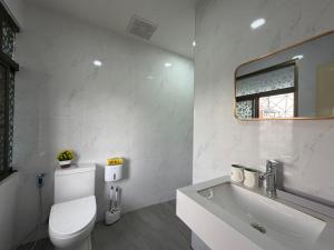 a bathroom with a toilet and a sink and a mirror at S Hostel Sukhumvit 48 in Bangkok +74 photos