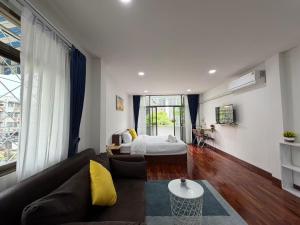 a living room with a couch and a bed at S Hostel Sukhumvit 48 in Bangkok