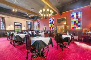 a dining room with tables and chairs and a chandelier at Quality Hotel Colonial Launceston in Launceston
