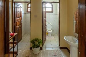 a bathroom with a toilet and a sink at Hansat Homestay Residence in Arusha +39 photos