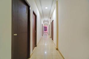 a corridor of a hallway with a pink door at FabHotel Gold Residency in Chennai