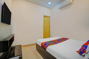a bedroom with a bed with a colorful blanket on it at FabHotel Gold Residency in Chennai