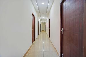 a corridor of a hallway with doors and tile floors at FabHotel Gold Residency in Chennai