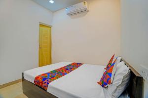 a bedroom with a bed with a colorful blanket on it at FabHotel Gold Residency in Chennai +19 photos