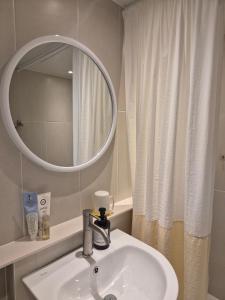 a bathroom with a sink and a mirror at 어게인수영 in Suyŏng