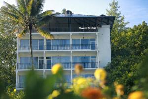 a hotel with a palm tree in front of it at Mount Minar Munnar in Anachal +12 photos
