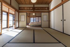 a bedroom with a bed in a room with windows at MITAMA House 01 ミタマ ハウス 01 in Ise