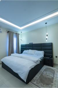 a bedroom with a large bed with a blue ceiling at Sanctum Suites in Abuja