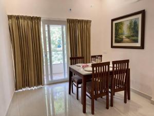 a dining room with a table and chairs and a window at Radial Serviced Apartments in Chennai