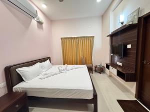 a bedroom with a bed and a television in it at Radial Serviced Apartments in Chennai