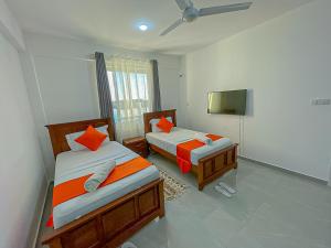 a bedroom with two beds and a tv in it at Aqua seaside Apartments in Mombasa
