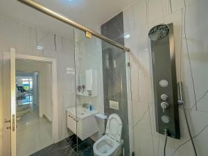 a bathroom with a white toilet and a shower at Aqua seaside Apartments in Mombasa +30 photos