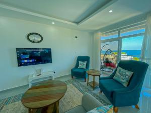 a living room with two blue chairs and a table at Aqua seaside Apartments in Mombasa