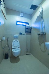 a bathroom with a toilet and a shower and a sink at Sanctum Suites in Abuja +7 photos