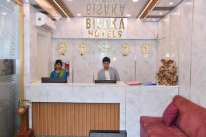 two people sitting at a counter with their laptops at Bisaka Hotels in Patna