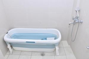 a bath tub in a bathroom with a shower at Bisaka Hotels in Patna +52 photos