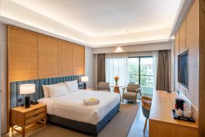a hotel room with a bed and a desk at Swiss-Grand Beach Resort Kuantan - Newly Upgraded 5-Star in Kuantan