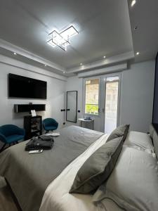 a bedroom with a bed with two chairs and a television at B&B GarbaCity-Inn in Rome