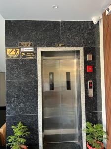 an elevator in a building with signs above it at Bhavya Guest House in Rīngas