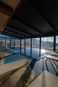 a building with a pool with tables and windows at Zafaron Premium Hotel in Chimgan