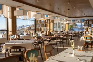 a restaurant with tables and chairs and windows at Zafaron Premium Hotel in Chimgan