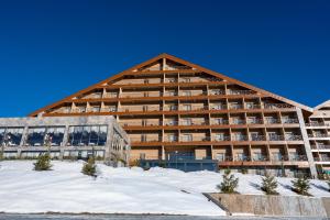 a large building with snow in front of it at Zafaron Premium Hotel in Chimgan