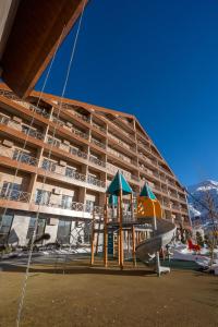 a playground in front of a large building at Zafaron Premium Hotel in Chimgan
