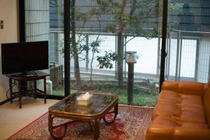 a living room with a couch and a glass coffee table at Law Firm ローファーム in Nagano