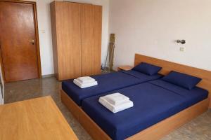 a bedroom with a blue bed with two towels on it at Stylish, 1-Bedroom at Watermill Complex in Bŭnzareto