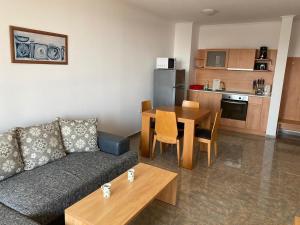 a living room with a couch and a table and a kitchen at Stylish, 1-Bedroom at Watermill Complex in Bŭnzareto