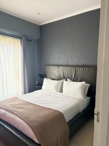 a bedroom with a large bed with a silver headboard at Tranquil Arcade in Boschrand