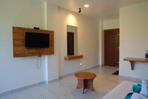 a living room with a flat screen tv on a wall at Mount Minar Munnar in Anachal