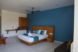 a bedroom with a bed with a blue wall at Mount Minar Munnar in Anachal