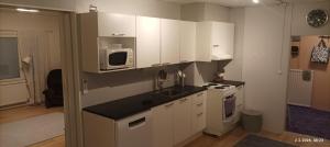 a kitchen with white cabinets and a microwave at Veteli in Veteli